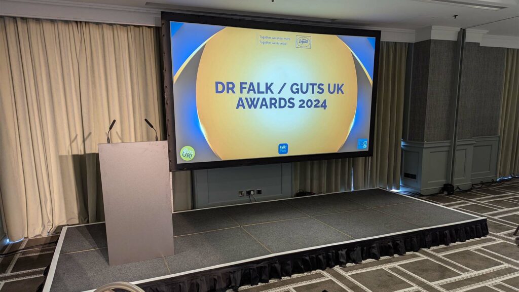 dr falk guts uk awards evening 2024 hyatt regency birmingham stage projector screen lectern microphones